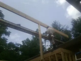 Carpenter setting a ridge beam over a new addition frame — Ice Dam Removal by Roofing Brothers in Tyngsboro