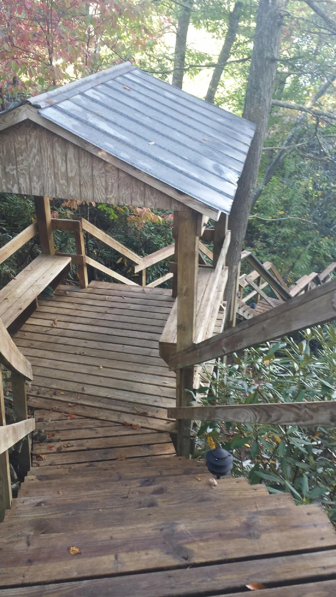 Metal roofed shelter over wooden steps on a wooded walkway — Skylight Repair & Installation work by our crew in Tyngsboro